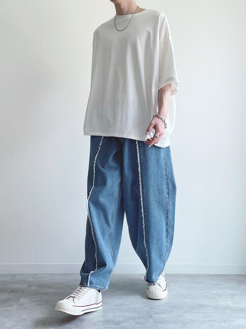 ホワイト系のTシャツ/カットソー、ブルー系のデニムパンツ、ホワイト系のスニーカーを着用したメンズの春コーディネートの5枚目の写真