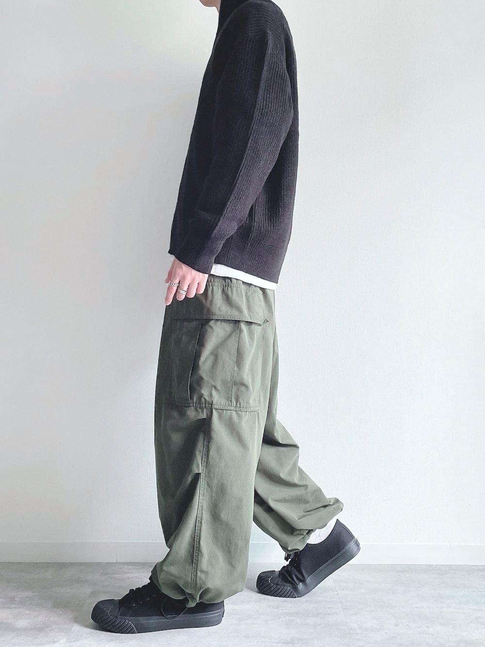 ブラック系のトップス、グレー系のトップス、グリーン系のカーゴパンツを着用したメンズの冬コーディネートの3枚目の写真