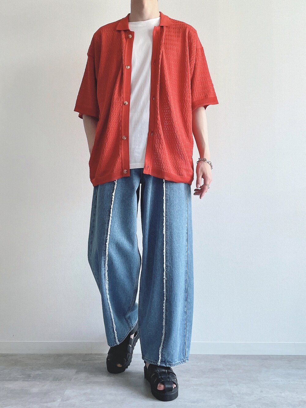 オレンジ系のシャツ/ブラウス、ホワイト系のタンクトップ、ブルー系のデニムパンツを着用したメンズの夏コーディネートの4枚目の写真