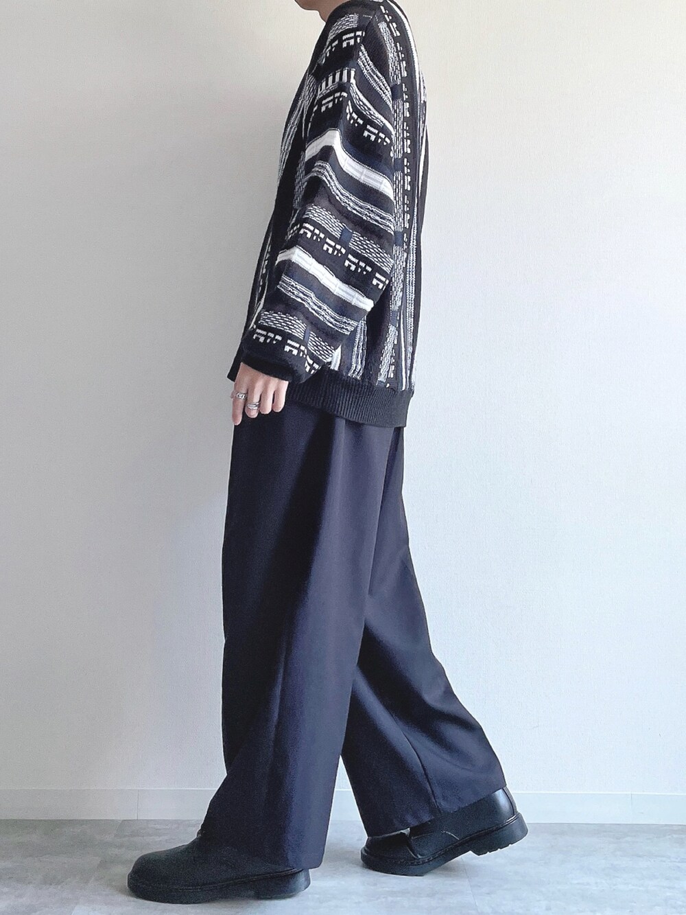 ブラック系のニット/セーター、ブラック系のスラックス、ブラック系のシューズを着用したメンズの冬コーディネートの3枚目の写真