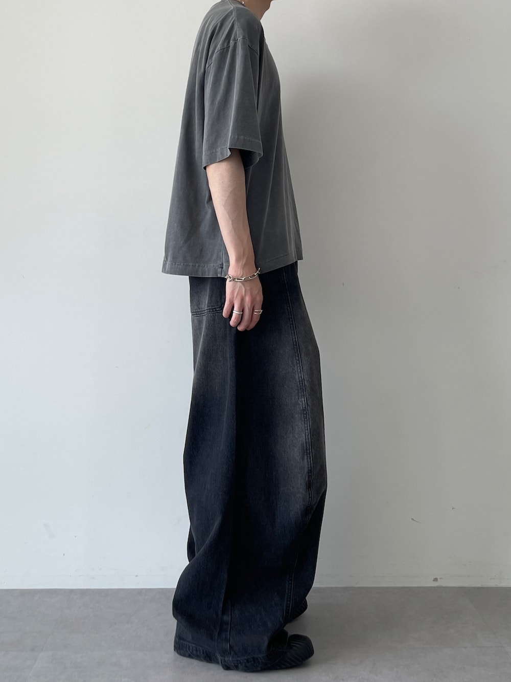 ブラック系のTシャツ/カットソー、ブラック系のデニムパンツ、ブラック系のスニーカーを着用したメンズの夏コーディネートの3枚目の写真