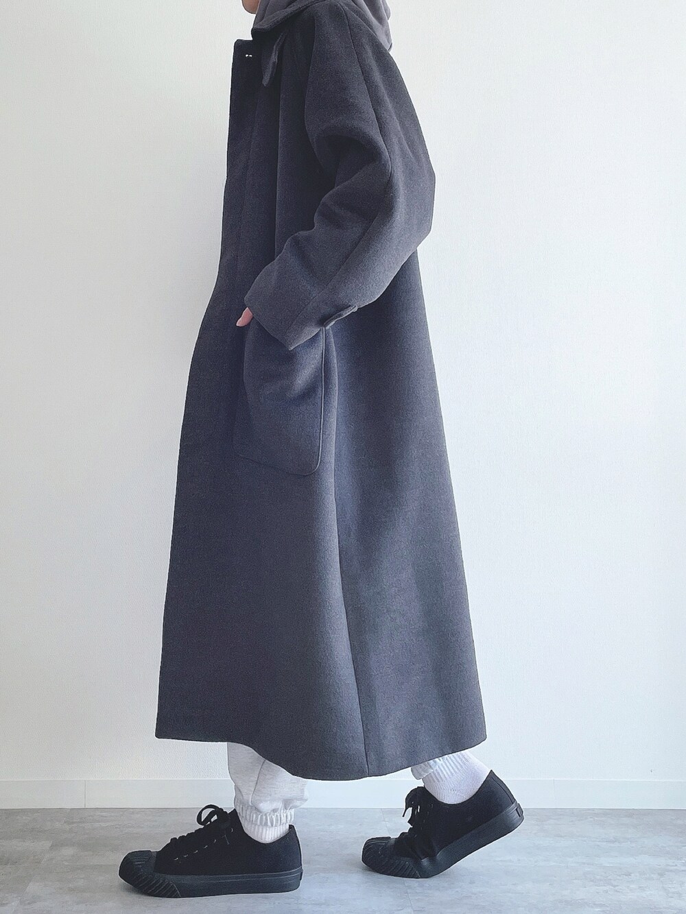 グレー系のステンカラーコート、ブルー系のTシャツ/カットソー、グレー系のスウェットパンツを着用したメンズの冬コーディネートの2枚目の写真