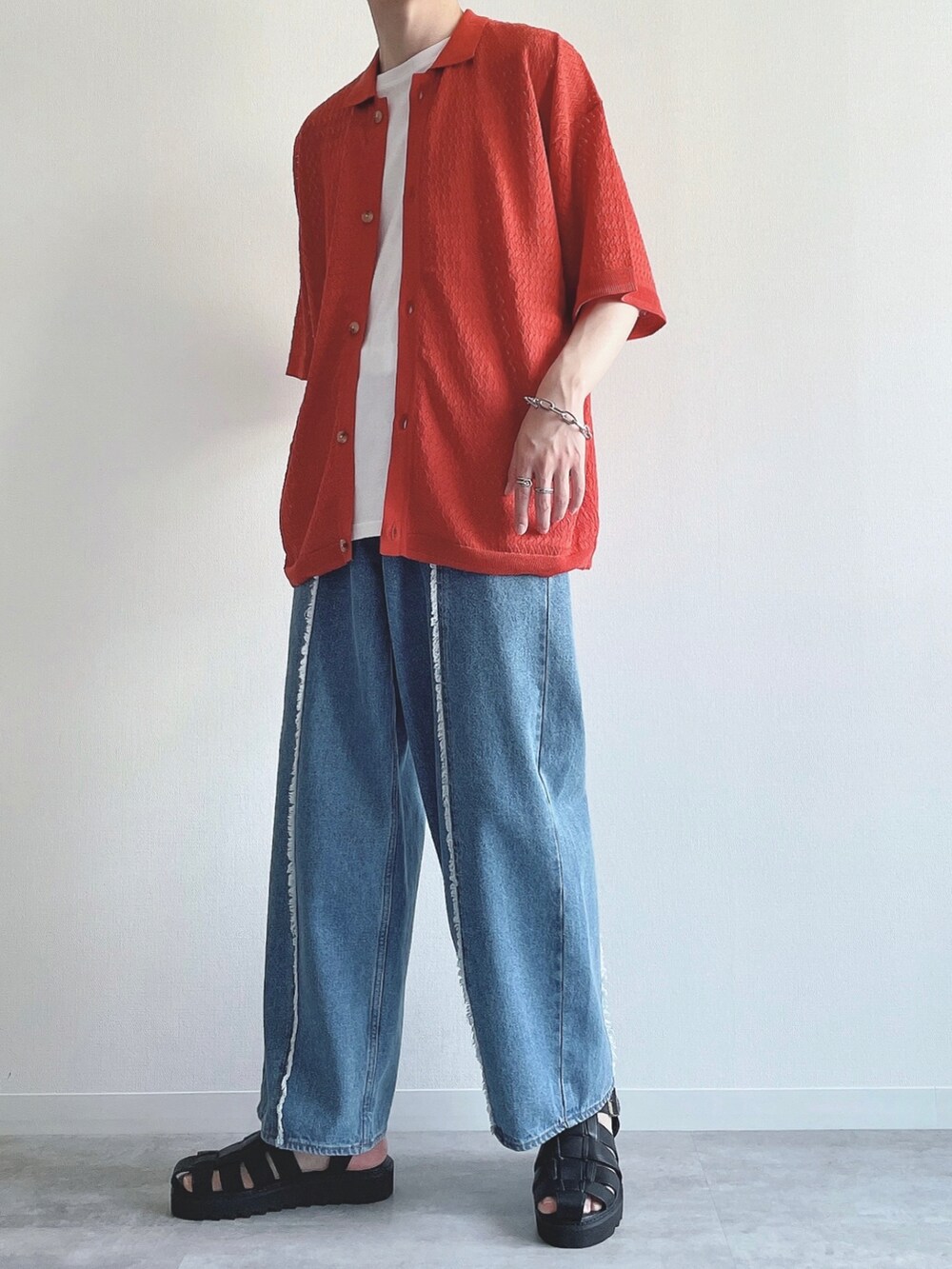 オレンジ系のシャツ/ブラウス、ホワイト系のタンクトップ、ブルー系のデニムパンツを着用したメンズの夏コーディネートの5枚目の写真