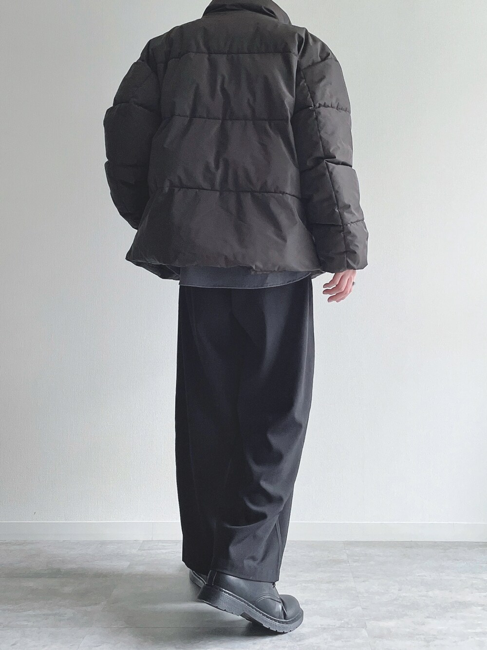 ブラック系のダウンジャケット/コート、ブラック系のトップス、ブラック系のスラックスを着用したメンズの冬コーディネートの3枚目の写真