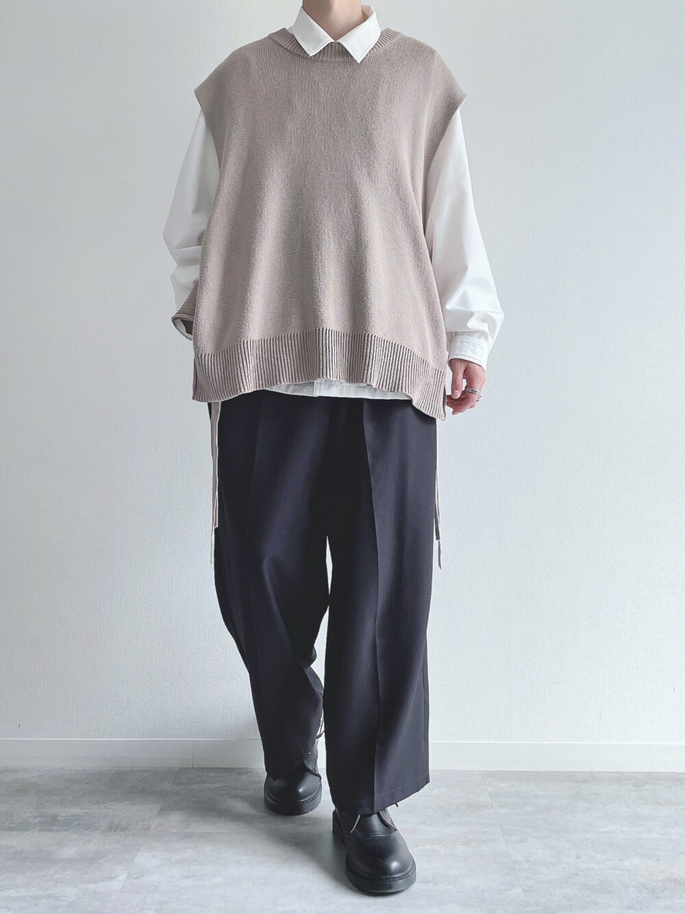 ベージュ系のベスト、ホワイト系のシャツ/ブラウス、ブラック系のスラックスを着用したメンズの秋コーディネートの2枚目の写真