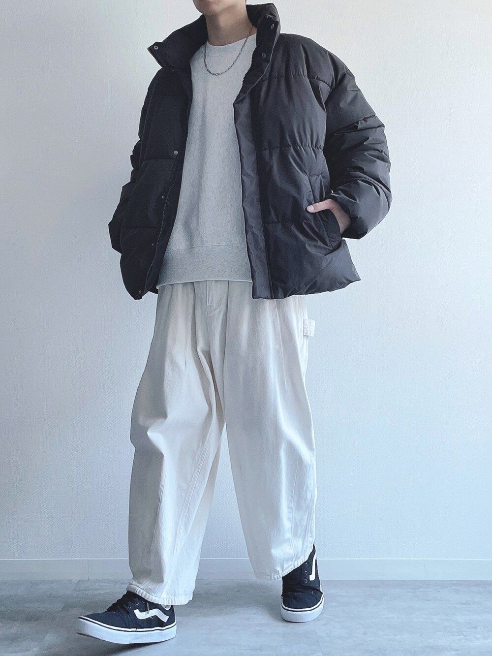 ブラック系のダウンジャケット/コート、グレー系のトップス、ベージュ系のパンツを着用したメンズの冬コーディネートの5枚目の写真