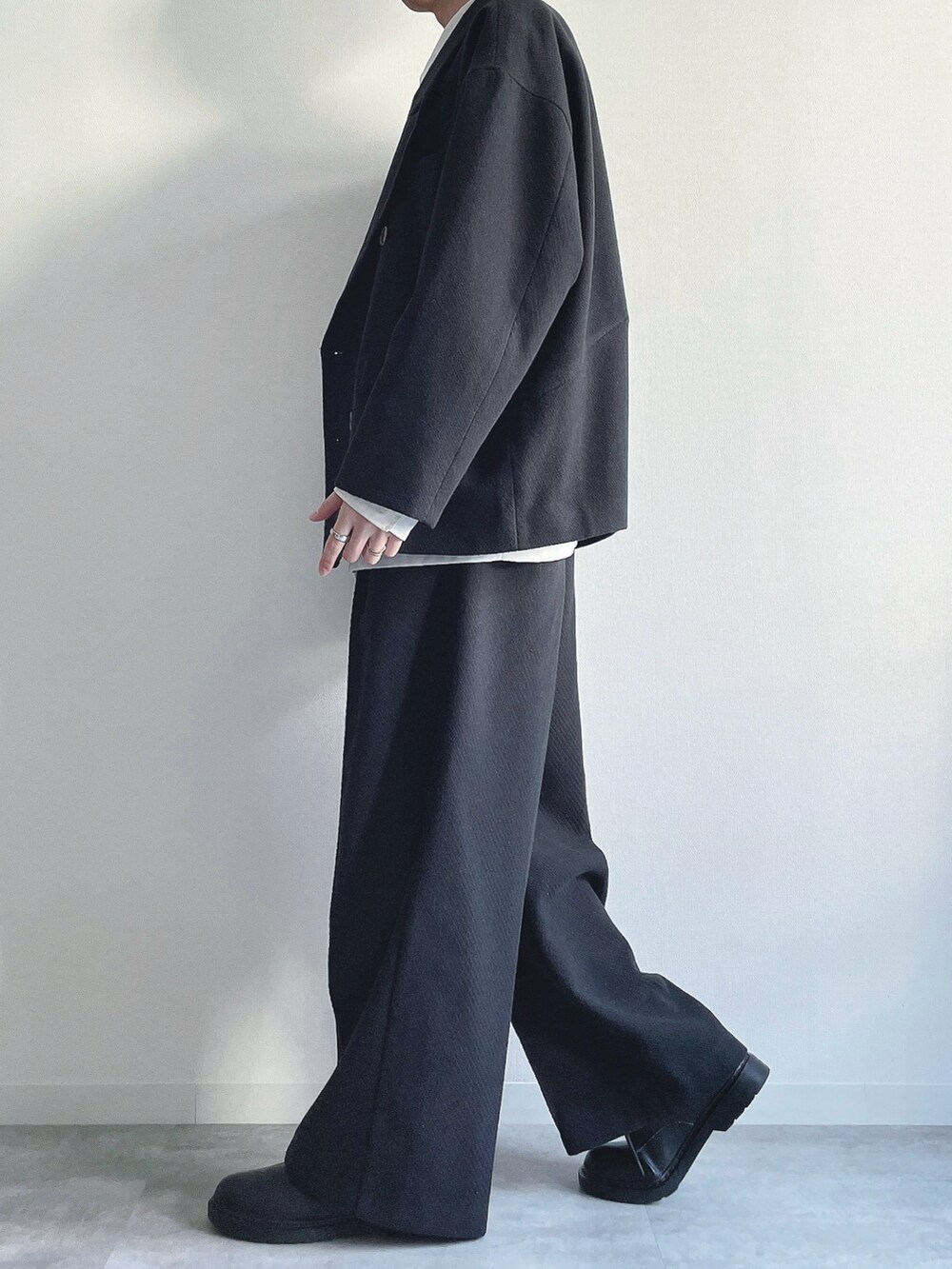 ブラック系のテーラードジャケット、ホワイト系のシャツ/ブラウス、ブラック系のスラックスを着用したメンズの冬コーディネートの3枚目の写真