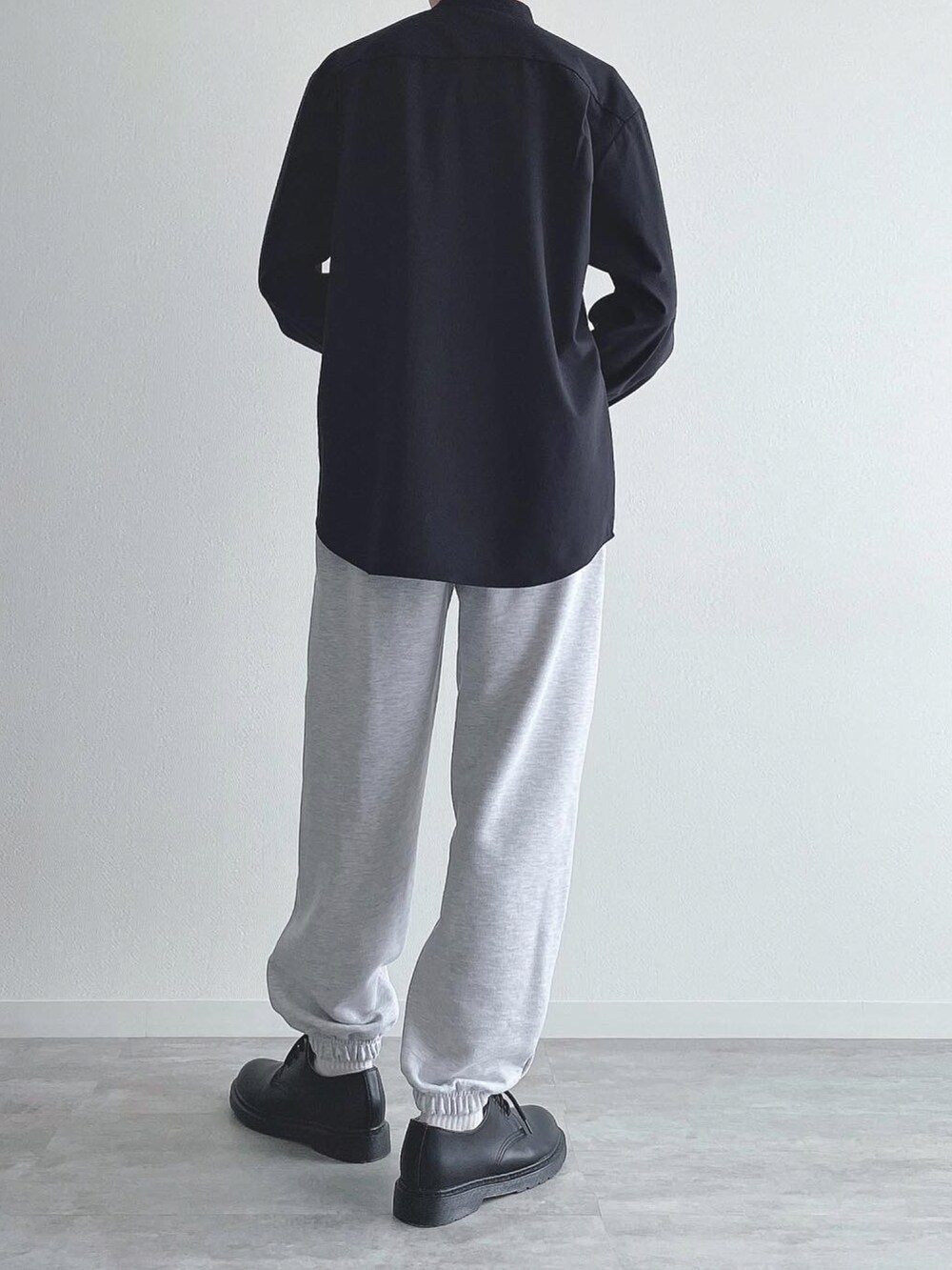 ブラック系のトップス、グレー系のスウェットパンツ、ブラック系のドレスシューズを着用したメンズの秋コーディネートの3枚目の写真