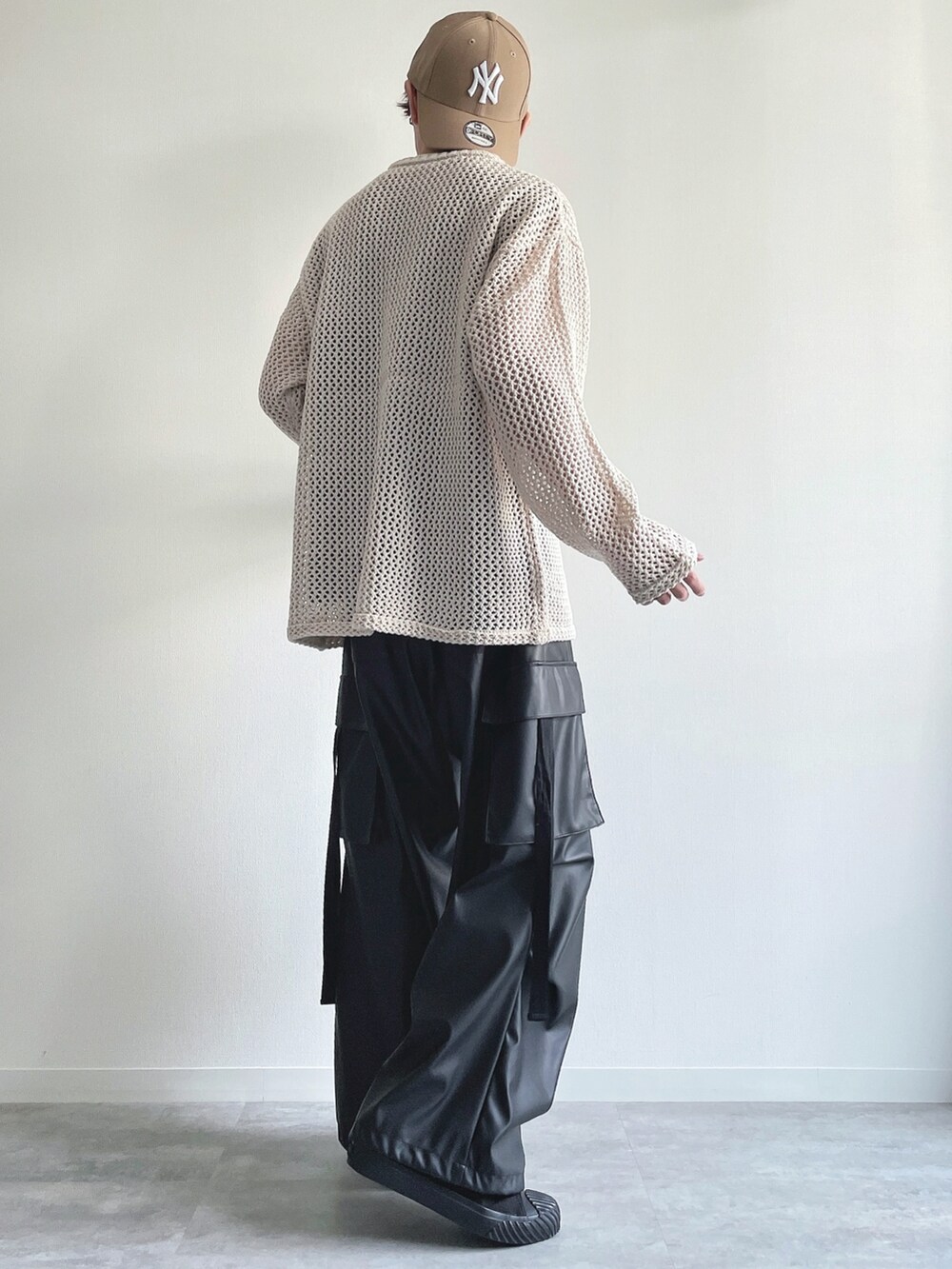 ホワイト系のニット/セーター、ブラック系のTシャツ/カットソー、ブラック系のカーゴパンツを着用したメンズの春コーディネートの4枚目の写真