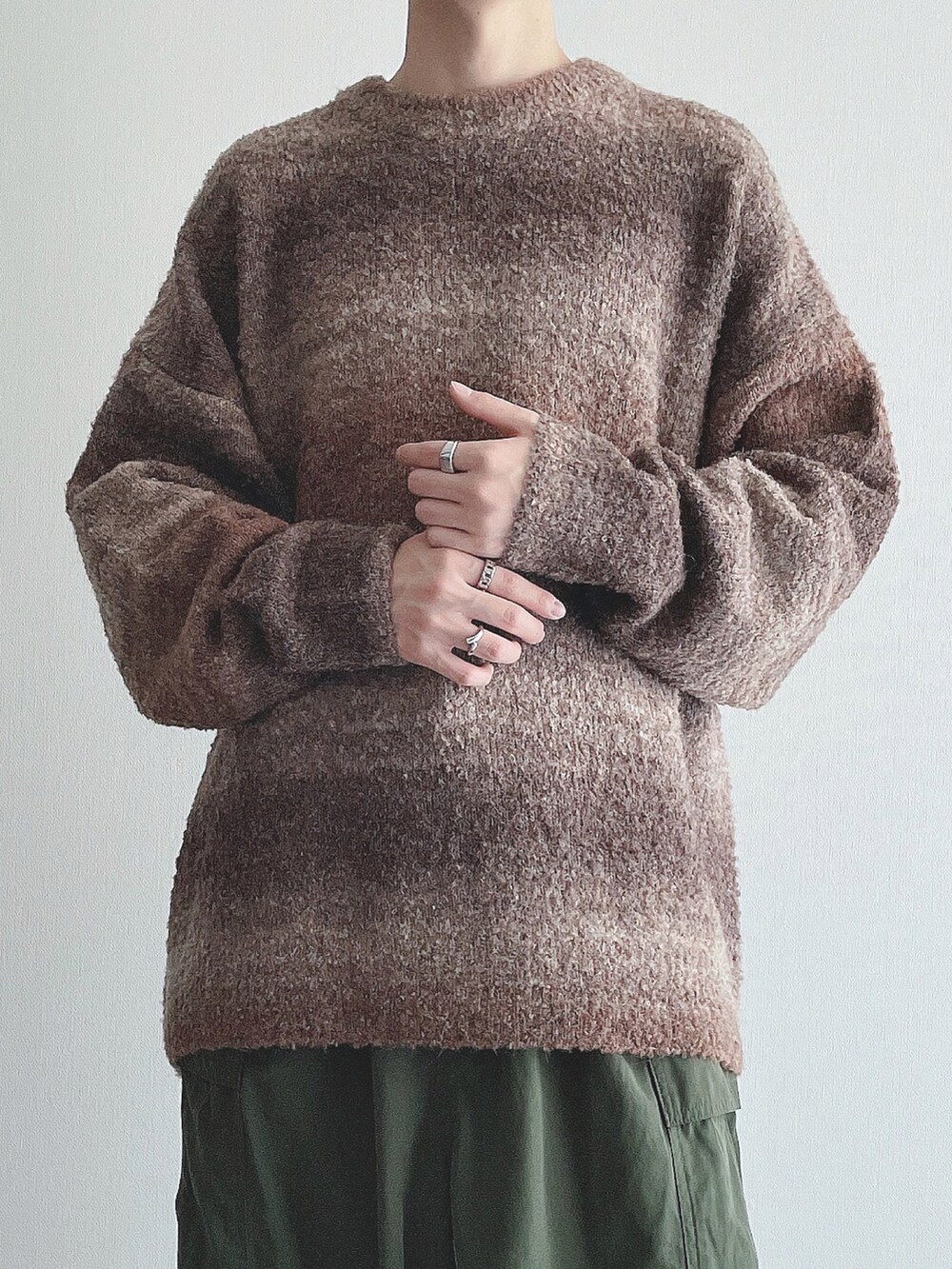 ブラウン系のニット/セーター、グリーン系のカーゴパンツ、ブラック系のスニーカーを着用したメンズの秋コーディネートの4枚目の写真