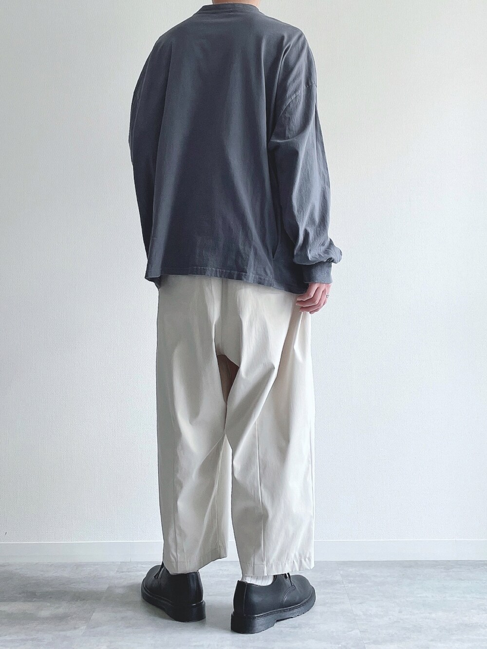 ブルー系のTシャツ/カットソー、ホワイト系のその他パンツ、ブラック系のドレスシューズを着用したメンズの春コーディネートの3枚目の写真