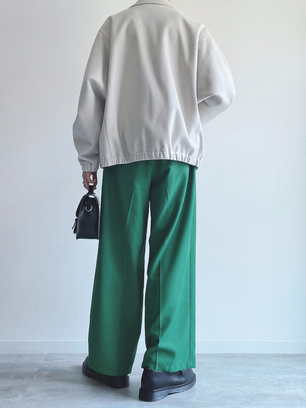 ホワイト系のブルゾン、ホワイト系のTシャツ/カットソー、グリーン系のスラックスを着用したメンズの春コーディネートの4枚目の写真