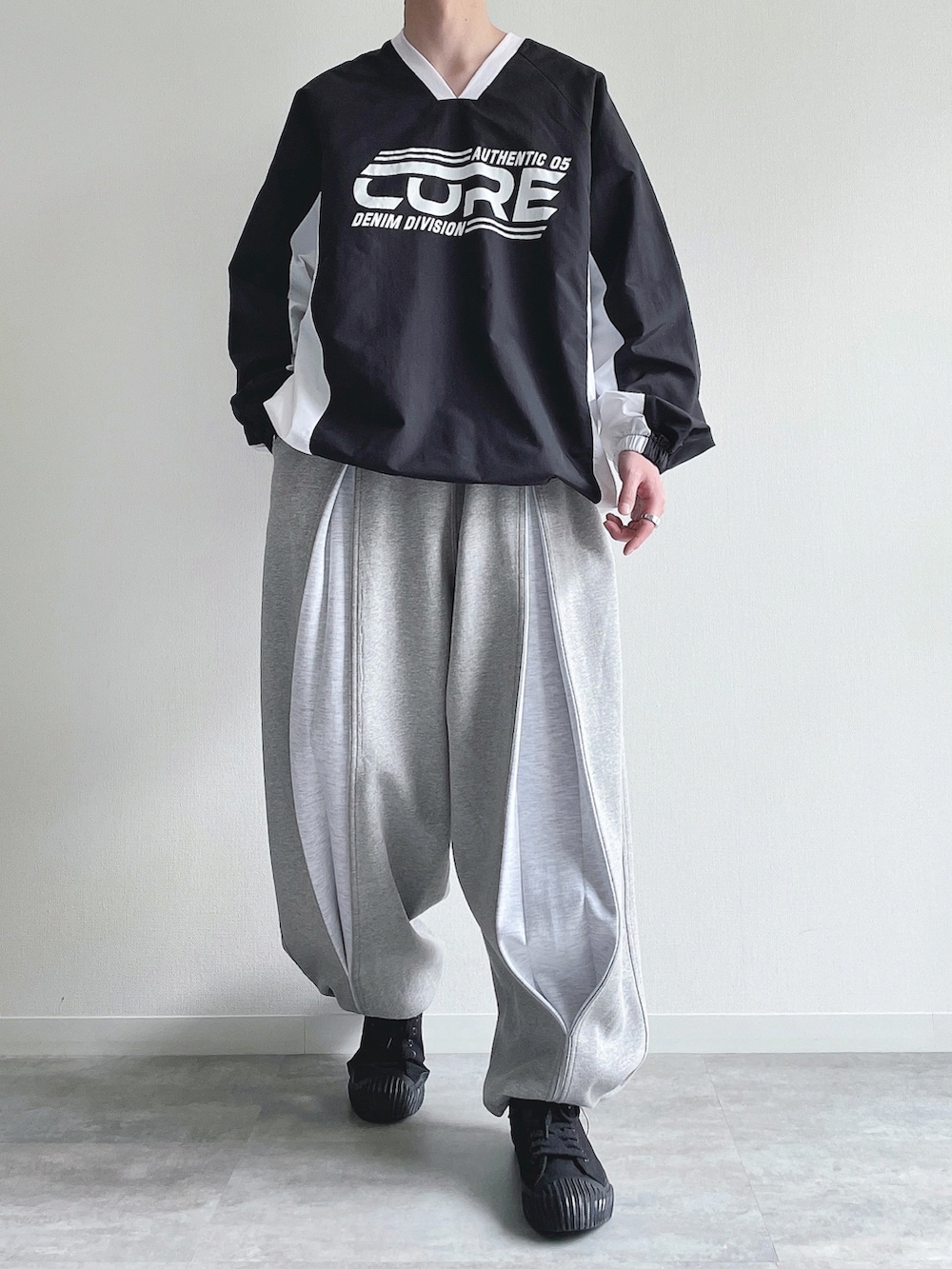 ブラック系のパーカー、グレー系のパンツ、ブラック系のスニーカーを着用したメンズの春コーディネートの2枚目の写真