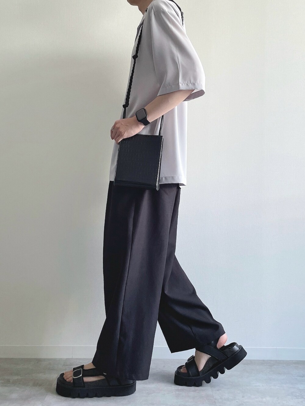 グレー系のトップス、ホワイト系のタンクトップ、ブラック系のスラックスを着用したメンズの夏コーディネートの3枚目の写真