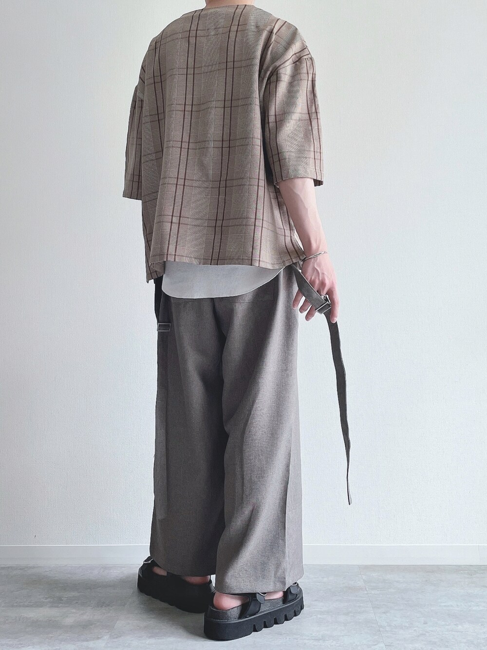 ブラウン系のTシャツ/カットソー、ホワイト系のタンクトップ、ベージュ系のスラックスを着用したメンズの夏コーディネートの4枚目の写真