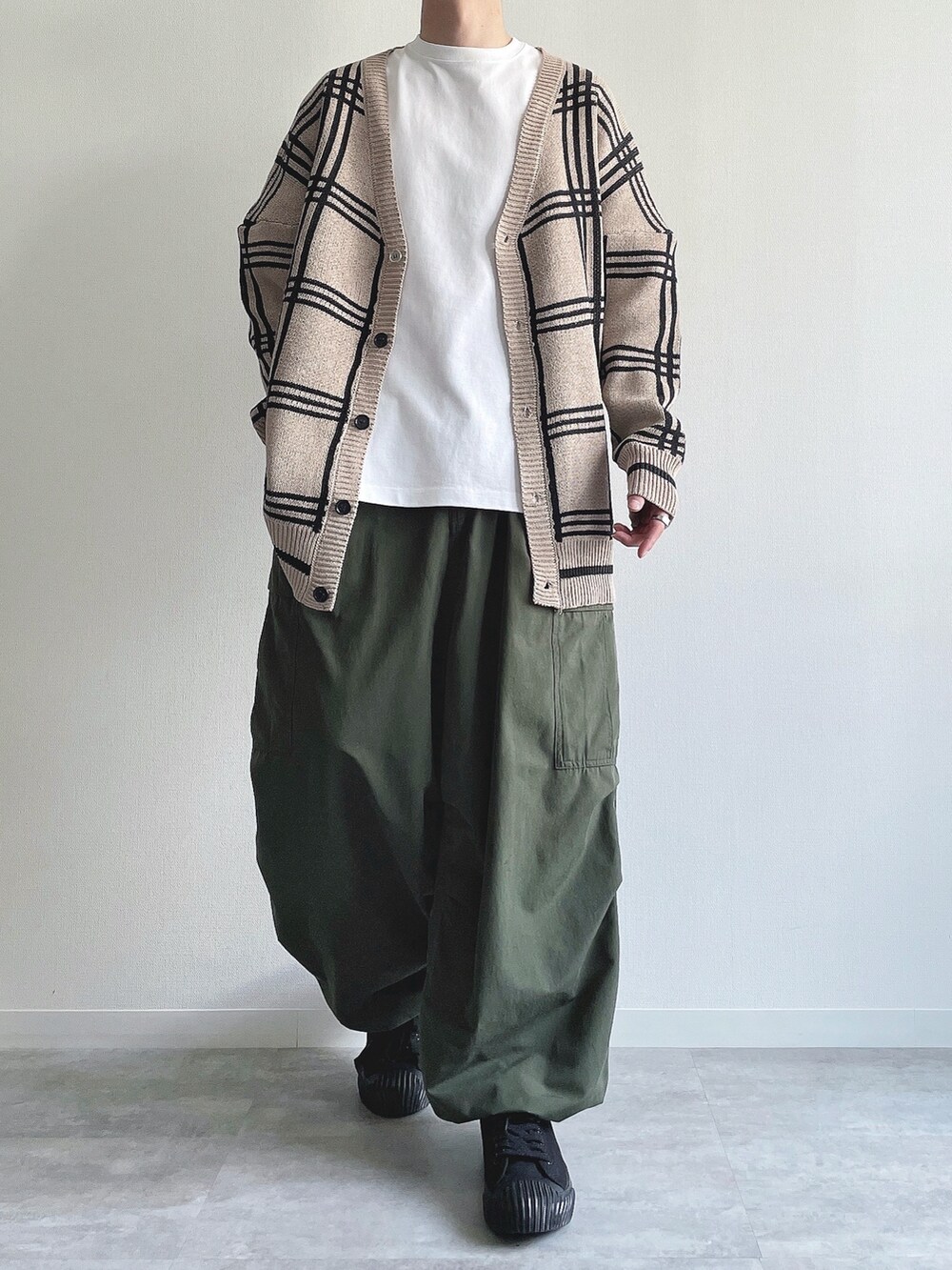 ベージュ系のカーディガン/ボレロ、ホワイト系のTシャツ/カットソー、グリーン系のカーゴパンツを着用したメンズの春コーディネートの2枚目の写真