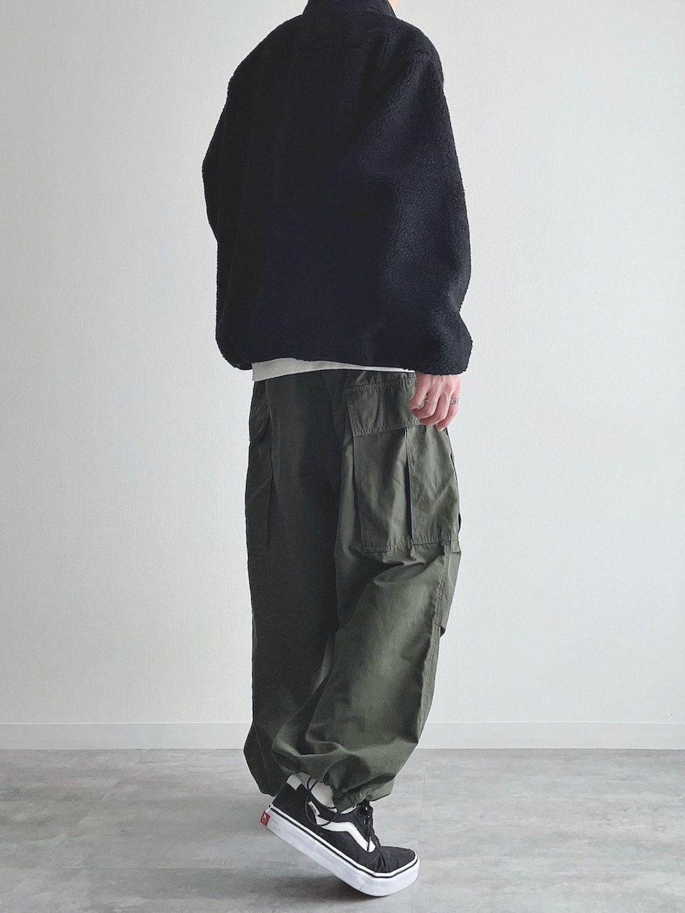 ブラック系のジャケット/アウター、ホワイト系のスウェット、グリーン系のカーゴパンツを着用したメンズの冬コーディネートの3枚目の写真