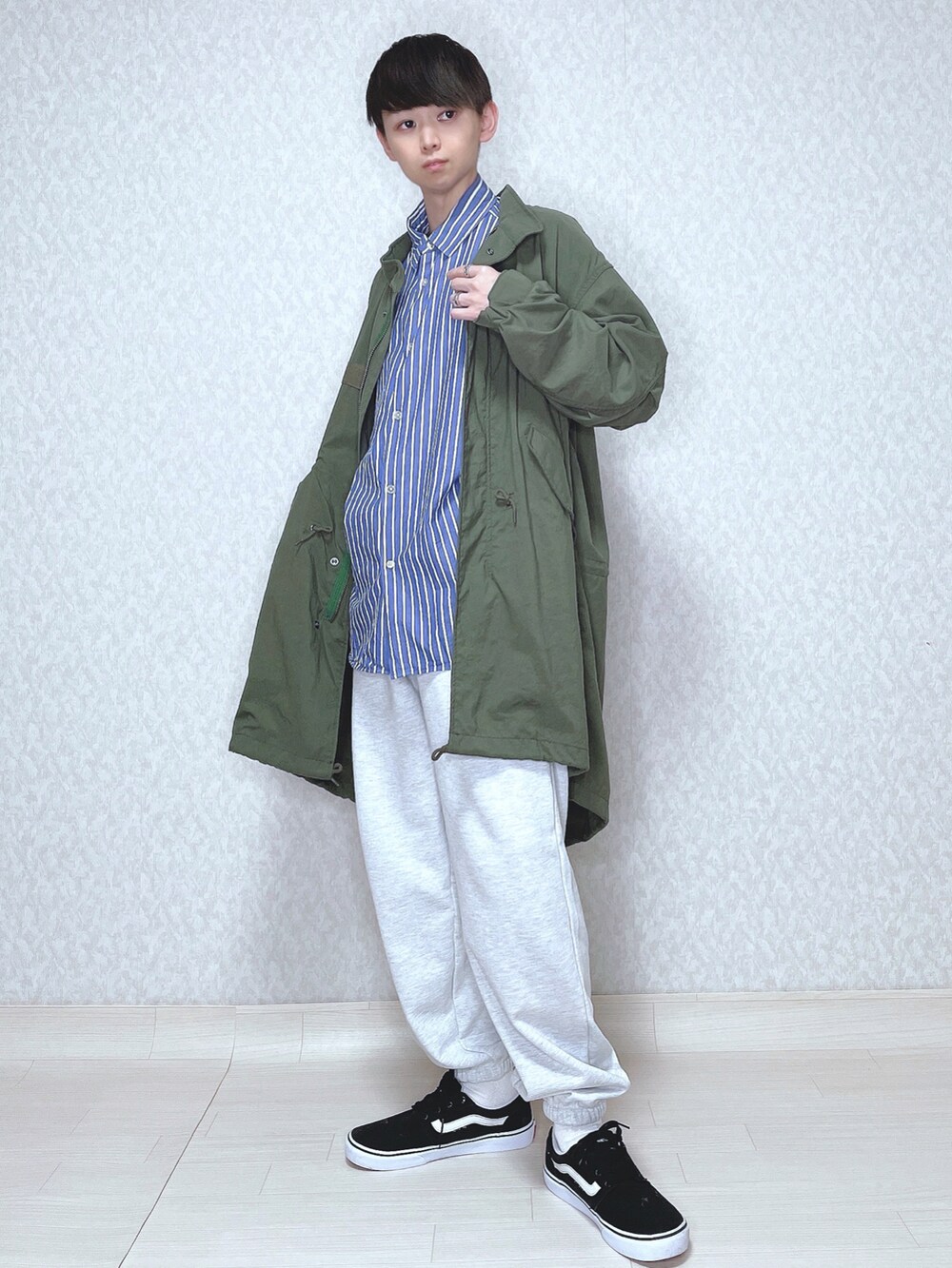 グリーン系のモッズコート、ブルー系のシャツ/ブラウス、グレー系のスウェットパンツを着用したメンズの春コーディネートの2枚目の写真