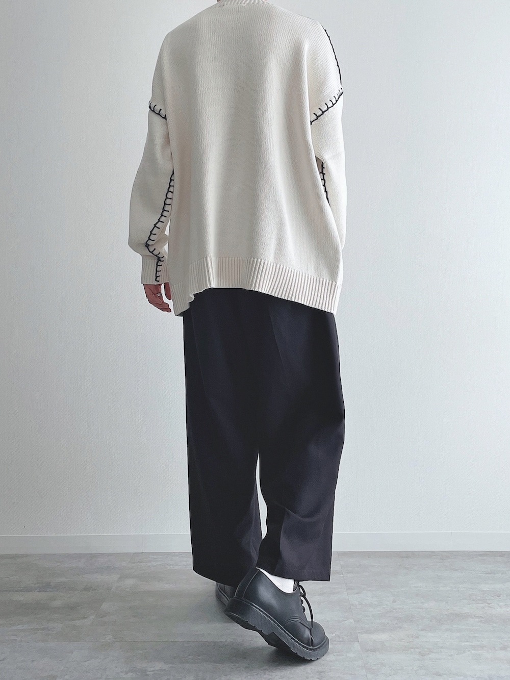 ホワイト系のニット/セーター、ブラック系のスラックス、ブラック系のドレスシューズを着用したメンズの秋コーディネートの4枚目の写真