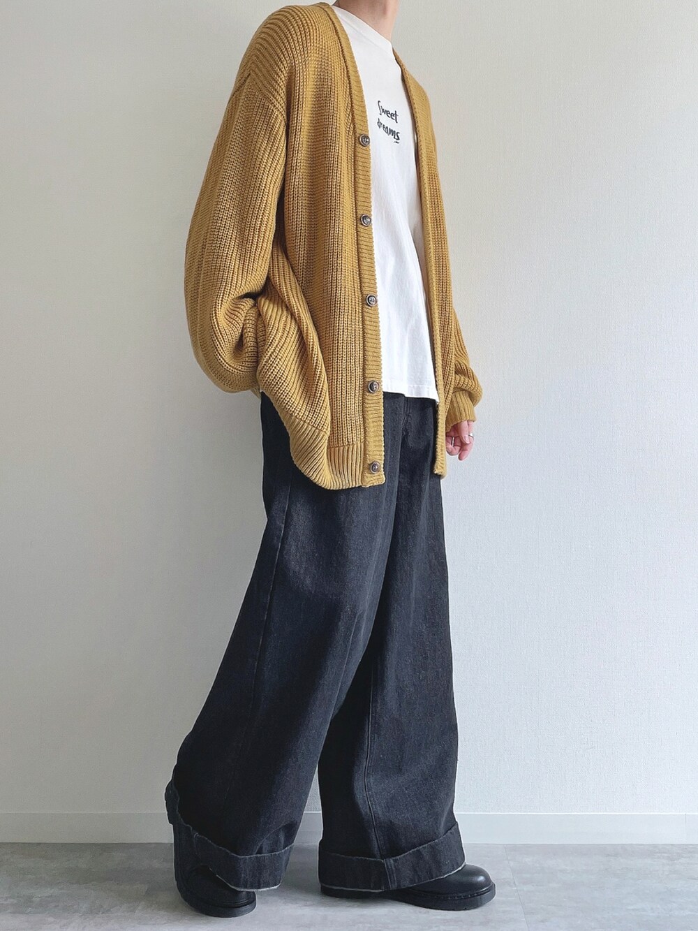 イエロー系のカーディガン/ボレロ、ホワイト系のTシャツ/カットソー、ブラック系のデニムパンツを着用したメンズの春コーディネートの5枚目の写真