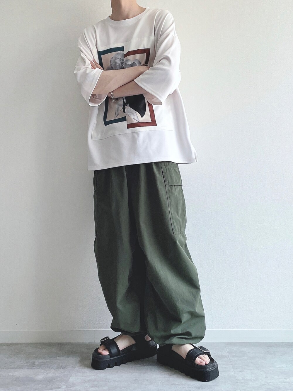 ホワイト系のTシャツ/カットソー、グリーン系のカーゴパンツ、ブラック系のサンダルを着用したメンズの夏コーディネートの4枚目の写真
