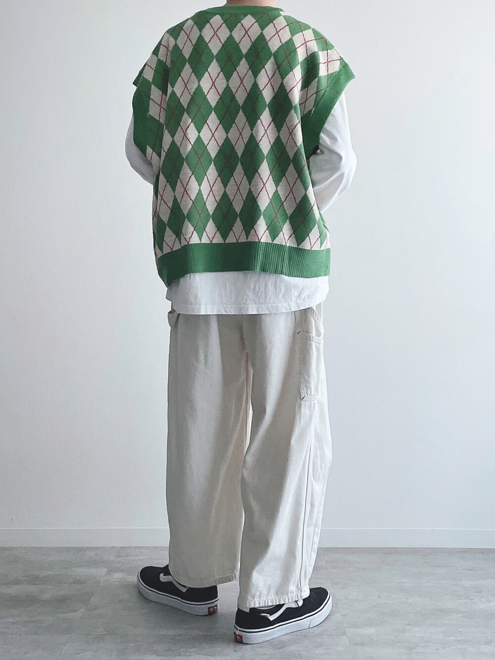 グリーン系のベスト、ホワイト系のTシャツ/カットソー、ベージュ系のパンツを着用したメンズの秋コーディネートの3枚目の写真