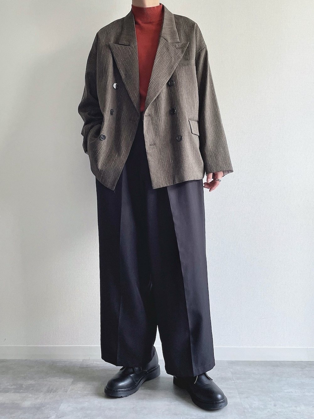 グリーン系のテーラードジャケット、レッド系のニット/セーター、ブラック系のスラックスを着用したメンズの冬コーディネートの2枚目の写真