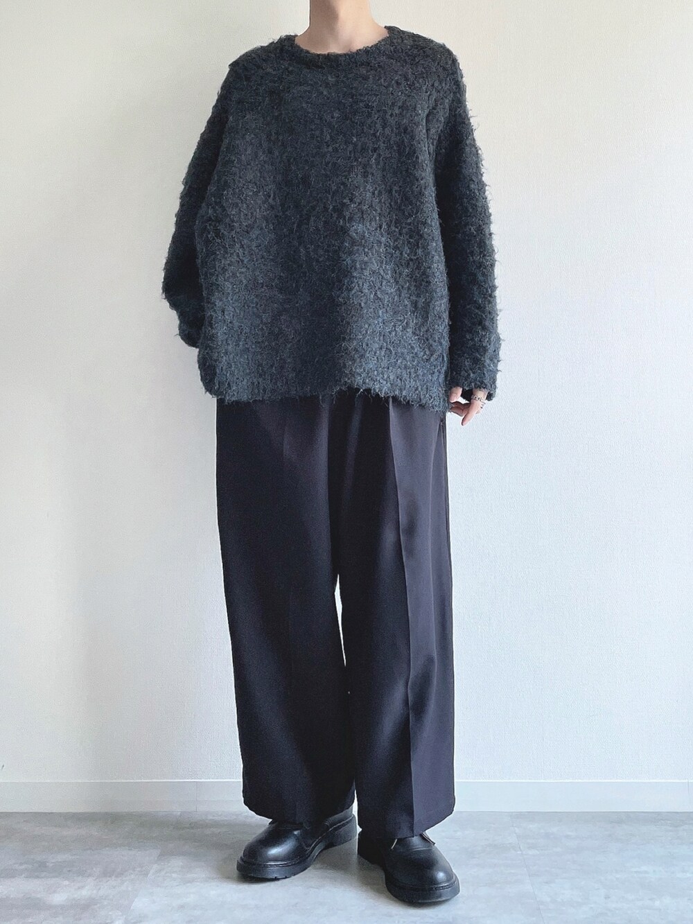 ブルー系のニット/セーター、ブラック系のスラックス、ブラック系のシューズを着用したメンズの秋コーディネートの2枚目の写真