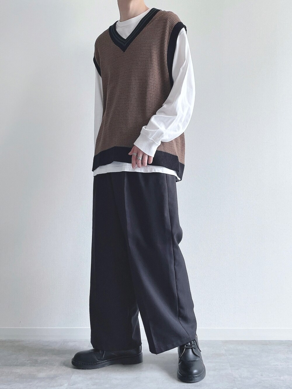 ホワイト系のTシャツ/カットソー、ブラウン系のトップス、ブラック系のスラックスを着用したメンズの秋コーディネートの5枚目の写真