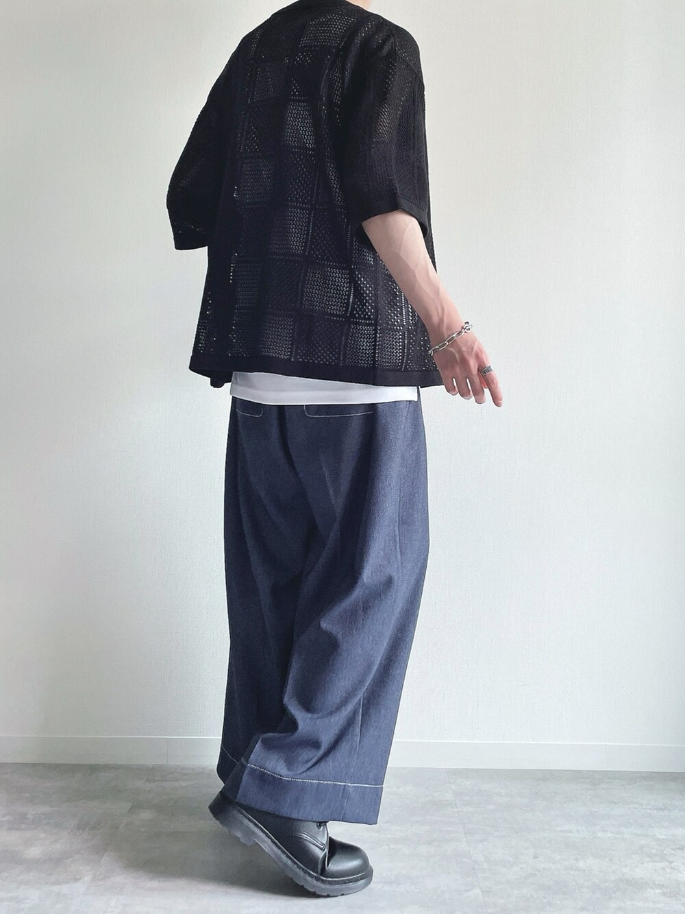 ブラック系のトップス、ホワイト系のタンクトップ、ブルー系のデニムパンツを着用したメンズの夏コーディネートの4枚目の写真