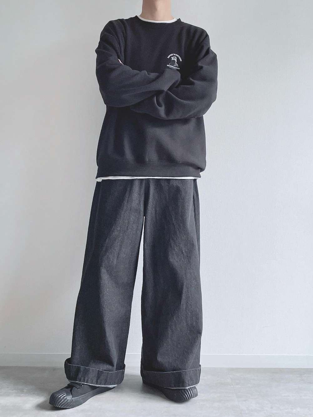 ブラック系のスウェット、ホワイト系のTシャツ/カットソー、ブラック系のデニムパンツを着用したメンズの冬コーディネートの5枚目の写真