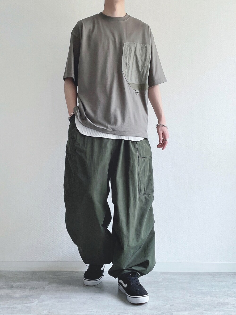 グリーン系のTシャツ/カットソー、ホワイト系のタンクトップ、グリーン系のカーゴパンツを着用したメンズの春コーディネートの2枚目の写真