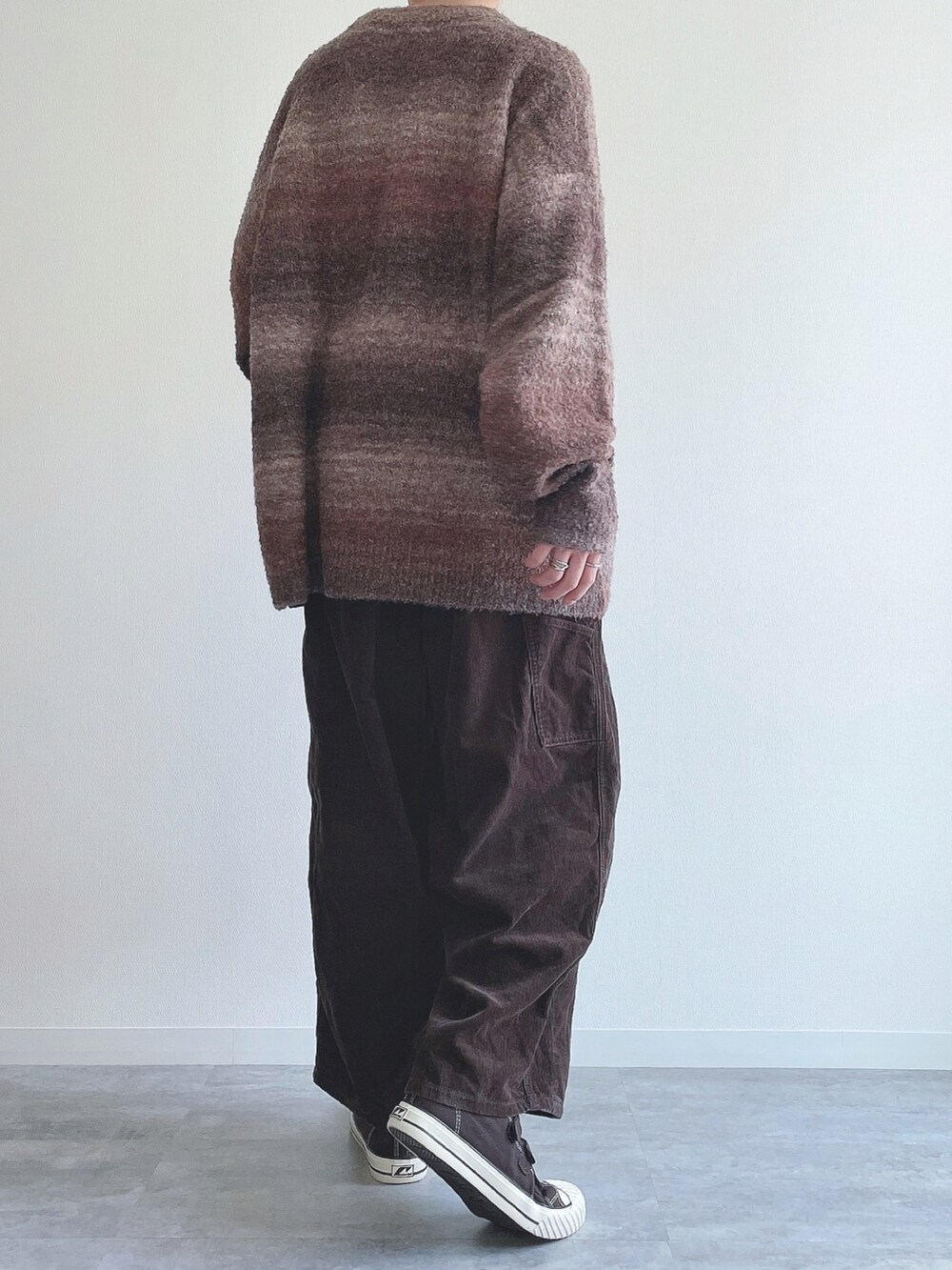 ブラウン系のニット/セーター、ブラウン系のその他パンツ、ブラウン系のスニーカーを着用したメンズの冬コーディネートの3枚目の写真