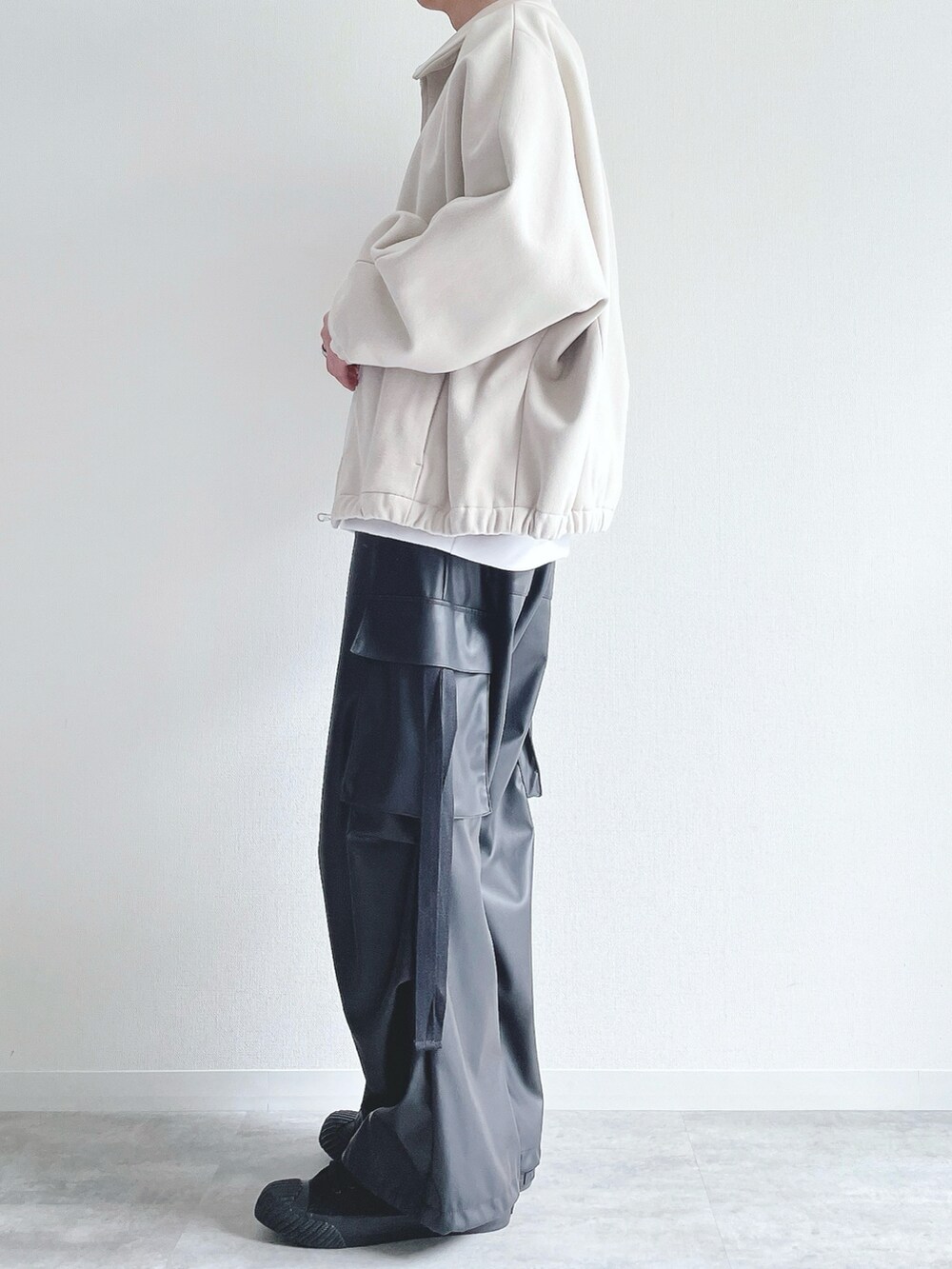 ホワイト系のブルゾン、ホワイト系のトップス、ブラック系のカーゴパンツを着用したメンズの冬コーディネートの3枚目の写真