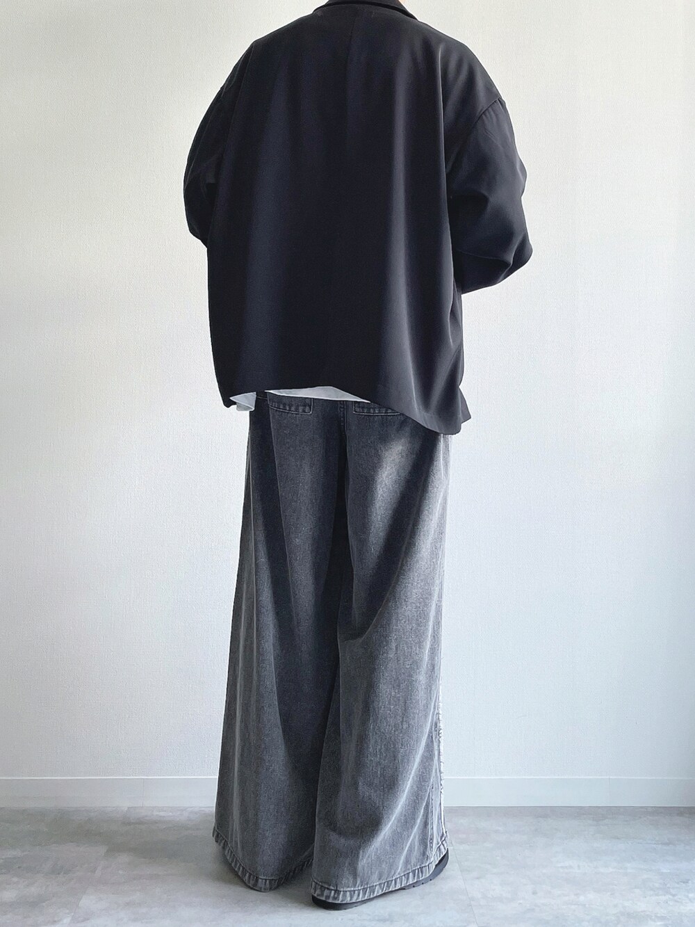 ブラック系のセットアップ、ホワイト系のTシャツ/カットソー、グレー系のデニムパンツを着用したメンズの春コーディネートの3枚目の写真
