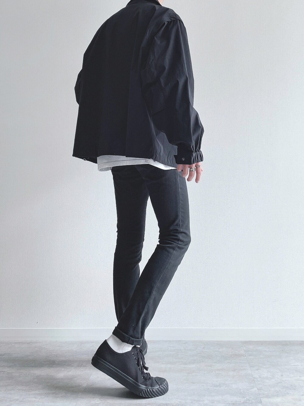 ブラック系のブルゾン、ホワイト系のTシャツ/カットソー、ブラック系のパンツを着用したメンズの秋コーディネートの4枚目の写真