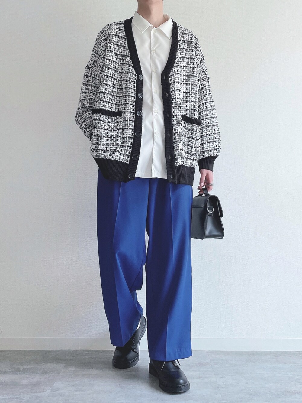 ブラック系のカーディガン/ボレロ、ホワイト系のシャツ/ブラウス、ブルー系のスラックスを着用したメンズの春コーディネートの4枚目の写真