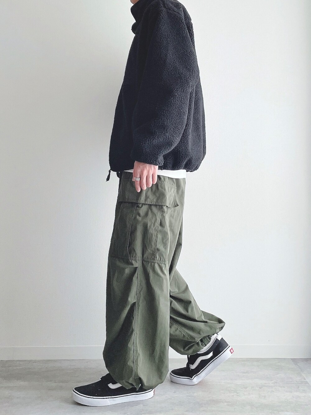 ブラック系のジャケット/アウター、ホワイト系のスウェット、グリーン系のカーゴパンツを着用したメンズの冬コーディネートの2枚目の写真