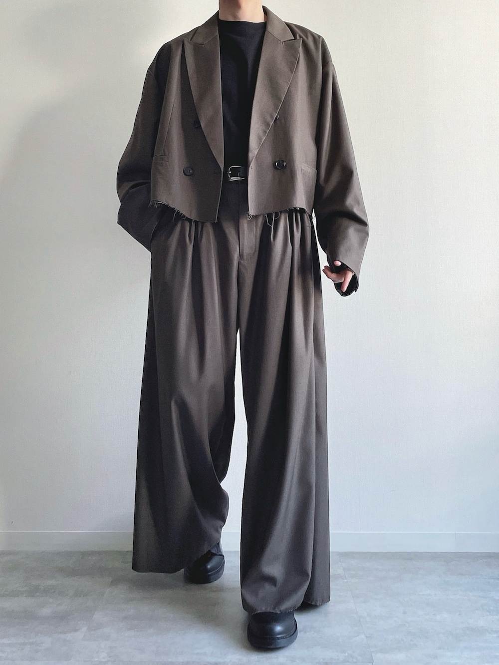 ベージュ系のテーラードジャケット、ベージュ系のスラックス、ブラック系のTシャツ/カットソーを着用したメンズの冬コーディネートの2枚目の写真