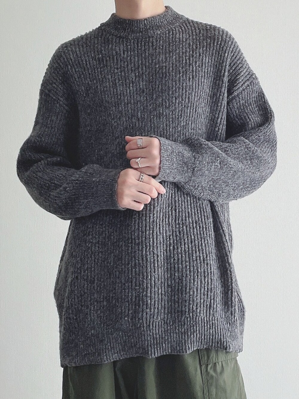 グレー系のニット/セーター、グリーン系のカーゴパンツ、ブラック系のローファーを着用したメンズの秋コーディネートの4枚目の写真