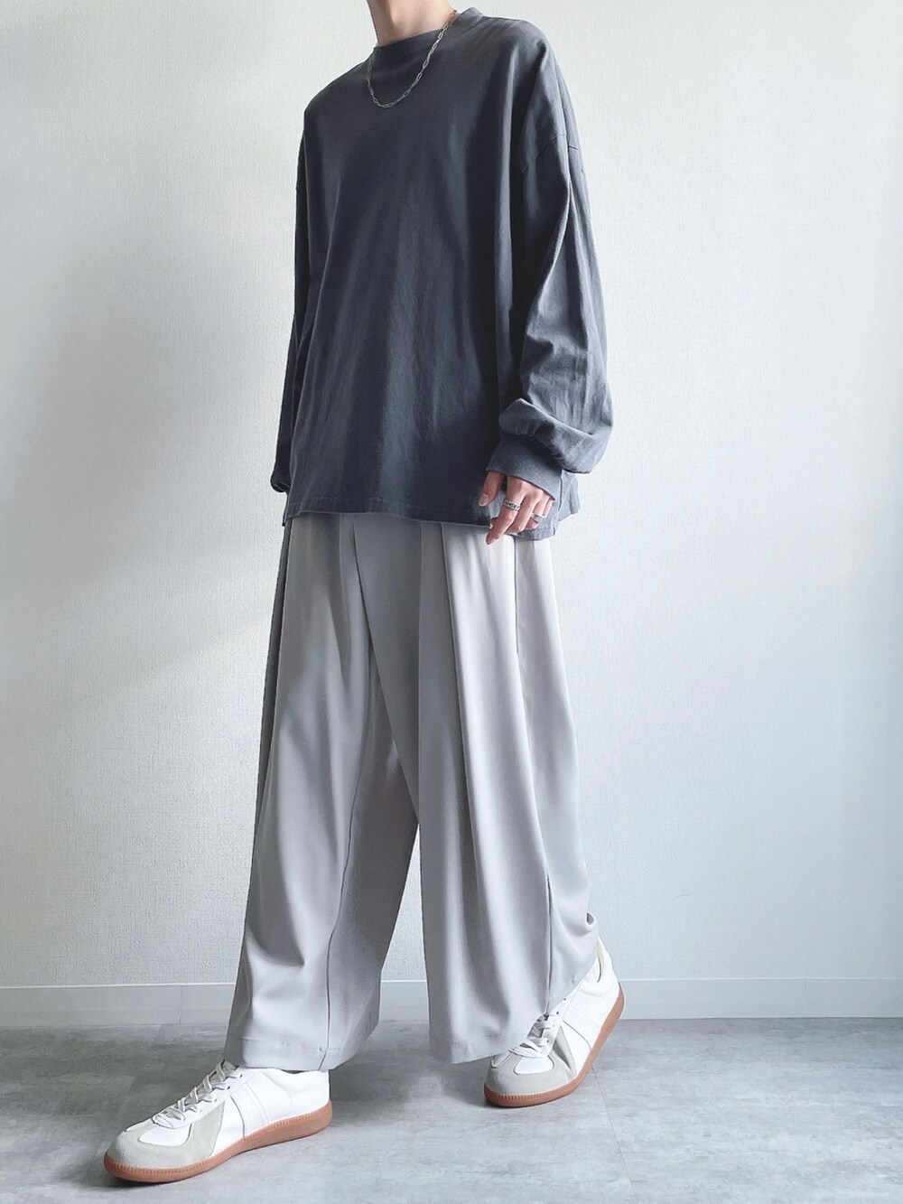 ブルー系のTシャツ/カットソー、グレー系のスラックス、ホワイト系のスニーカーを着用したメンズの秋コーディネートの5枚目の写真