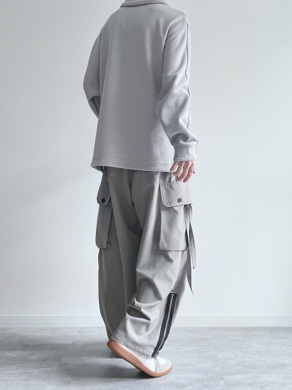 グレー系のカーゴパンツ、ホワイト系のスニーカー、シルバー系のブレスレットを着用したメンズの春コーディネートの4枚目の写真