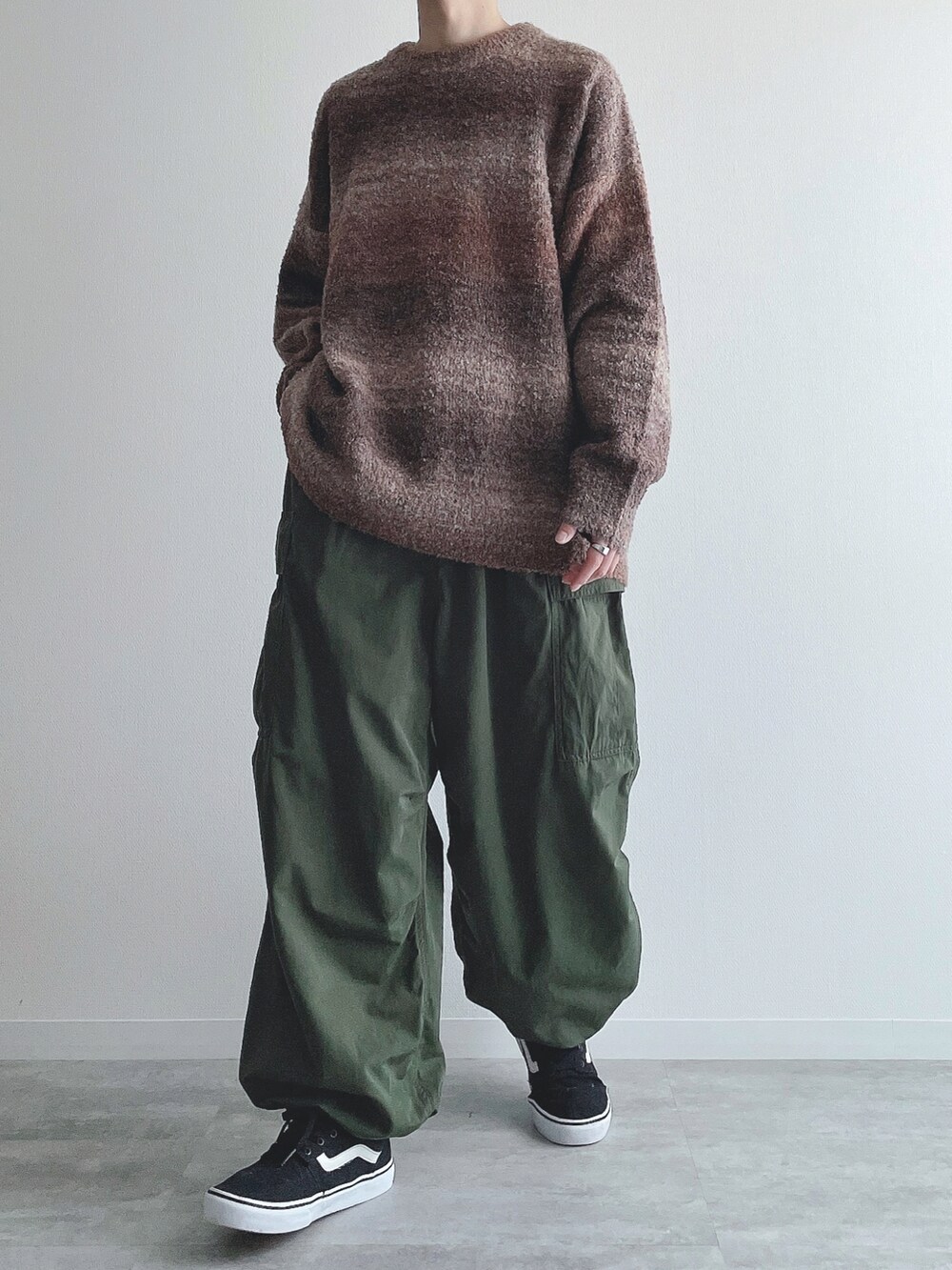 ブラウン系のニット/セーター、グリーン系のカーゴパンツ、ブラック系のスニーカーを着用したメンズの秋コーディネートの5枚目の写真