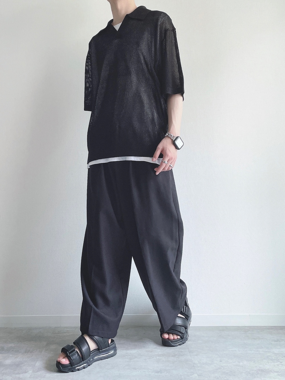 ブラック系のトップス、ホワイト系のタンクトップ、ブラック系のスラックスを着用したメンズの夏コーディネートの5枚目の写真