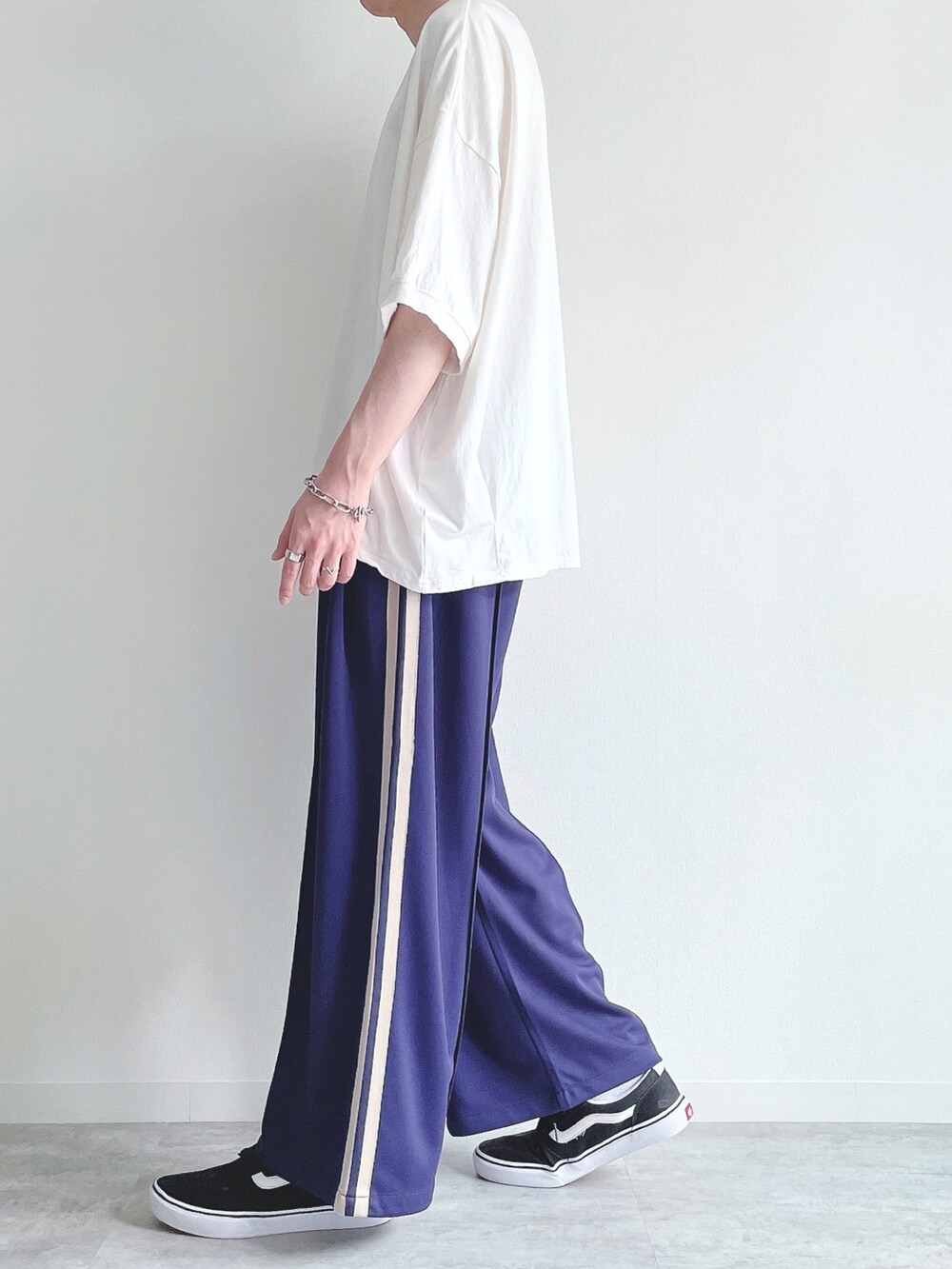 ホワイト系のTシャツ/カットソー、ブルー系のその他パンツ、ブラック系のスニーカーを着用したメンズの夏コーディネートの3枚目の写真