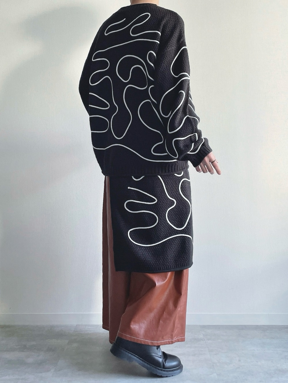 ブラック系のニット/セーター、ブラック系のスカート、ブラウン系のその他パンツを着用したメンズの冬コーディネートの3枚目の写真