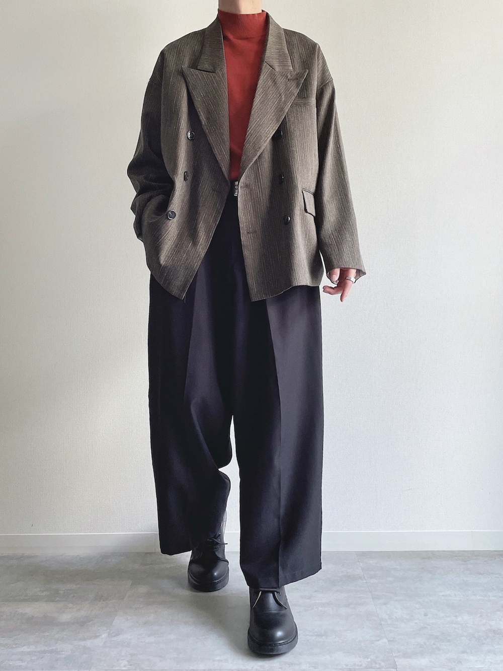 グリーン系のテーラードジャケット、レッド系のニット/セーター、ブラック系のスラックスを着用したメンズの冬コーディネートの3枚目の写真