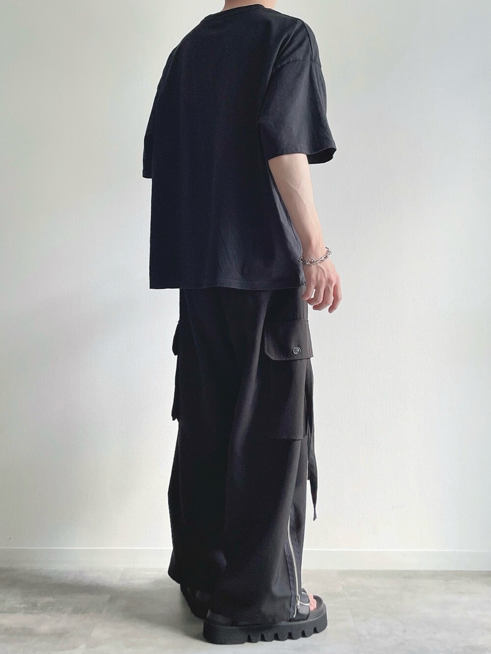 ブラック系のTシャツ/カットソー、ブラック系のカーゴパンツ、ブラック系のサンダルを着用したメンズの夏コーディネートの4枚目の写真