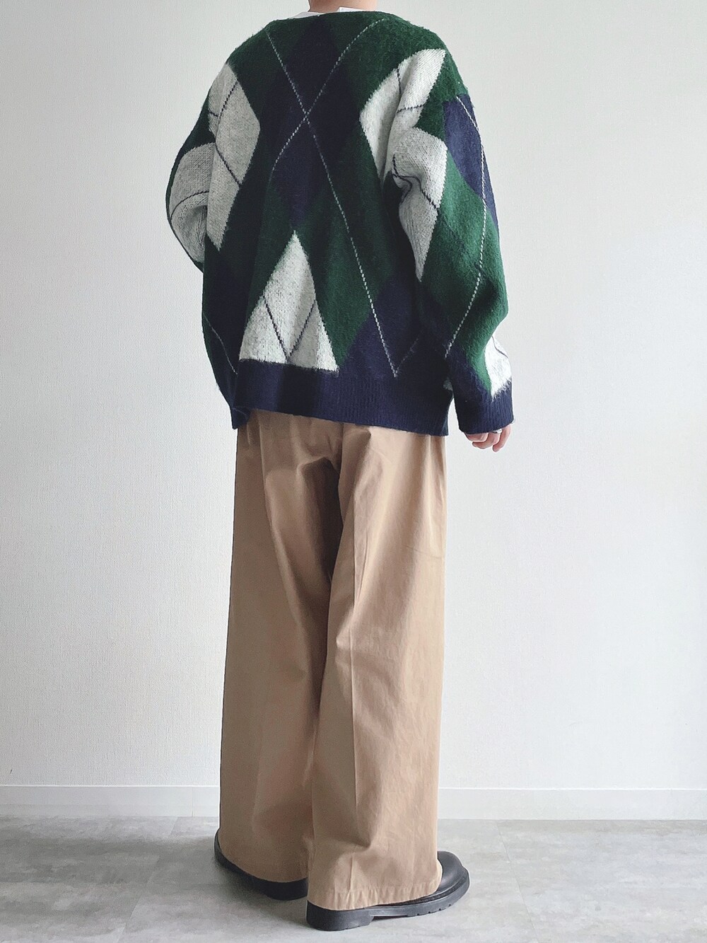 グリーン系のカーディガン/ボレロ、ホワイト系のTシャツ/カットソー、ベージュ系のチノパンツを着用したメンズの冬コーディネートの3枚目の写真