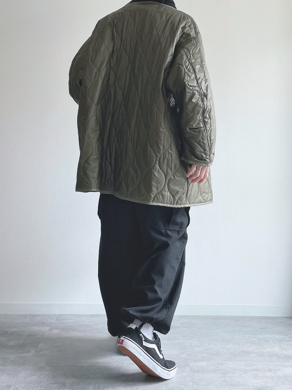 グリーン系のノーカラージャケット、ブラウン系のスウェット、ブラック系のその他パンツを着用したメンズの冬コーディネートの3枚目の写真